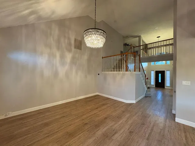 a view of empty room with wooden floor and fireplace