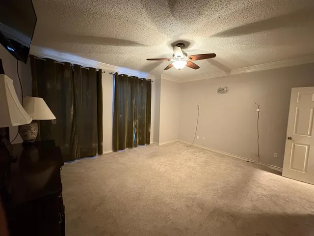 a large bedroom with a large bed and a chandelier