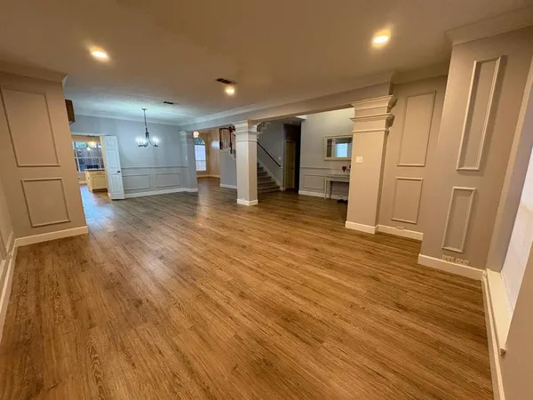 a view of empty room with wooden floor