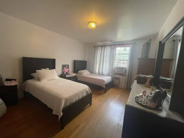 a bedroom with two beds and a window