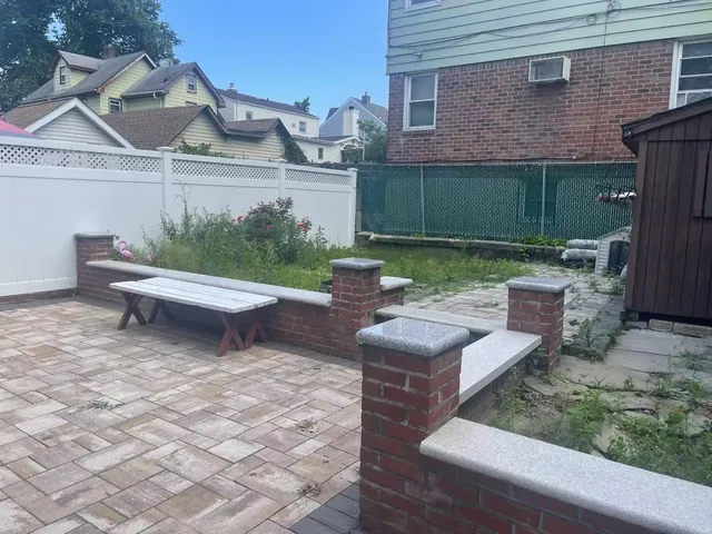 a view of a patio with table and chairs with wooden fence and plants