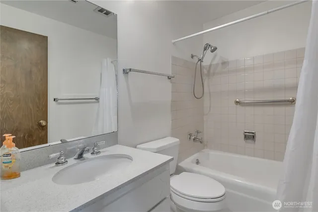 a bathroom with a granite countertop toilet a sink and a bathtub