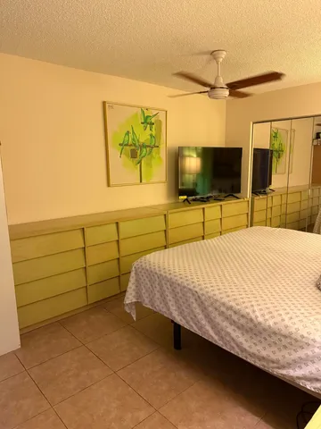 a bed sitting in a bedroom and a flat screen tv