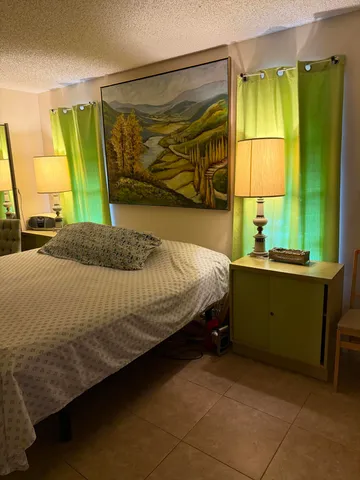 a bedroom with a bed and a painting on the wall