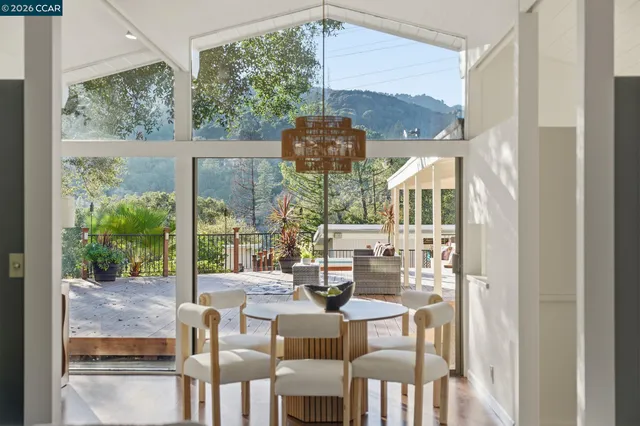 a view of a dining room with furniture large windows and backyard