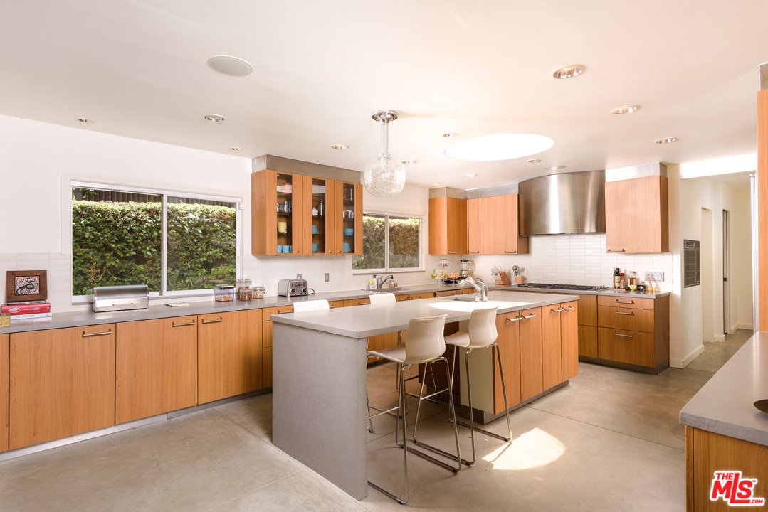 871 Leonard Road Los Angeles, CA 90049 - Photo 11 of 28 a kitchen with lots of counter top space and dining table