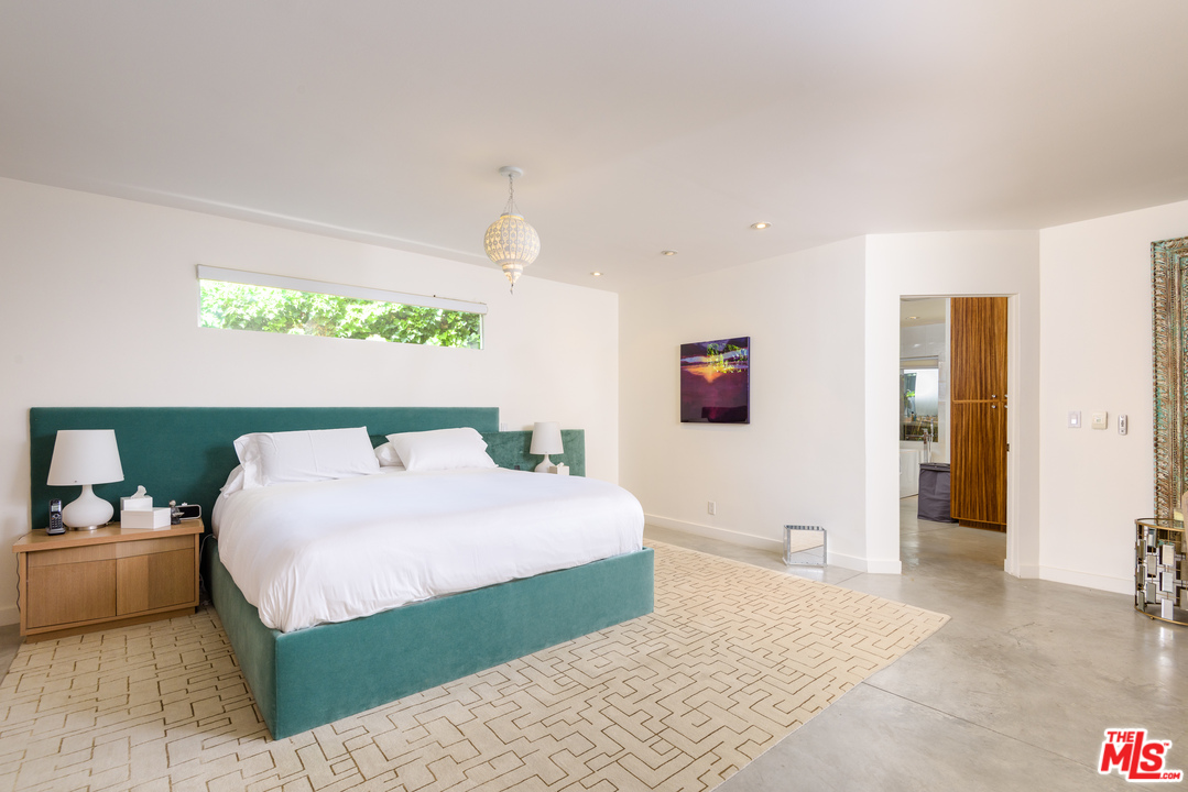 871 Leonard Road Los Angeles, CA 90049 - Photo 17 of 28 a bedroom with a bed mirror and window