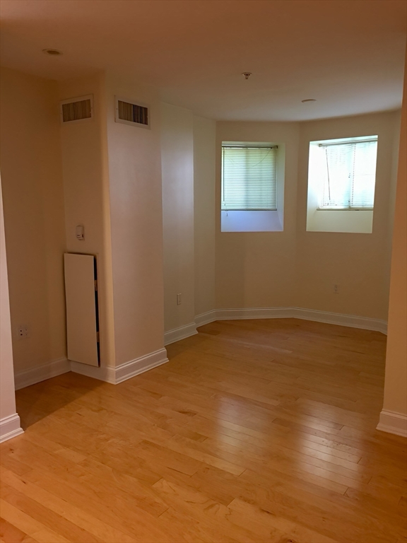 20 Chapel Street, Unit C308 Brookline, MA 02446 - Photo 3 of 15 a view of an empty room with wooden floor and a window