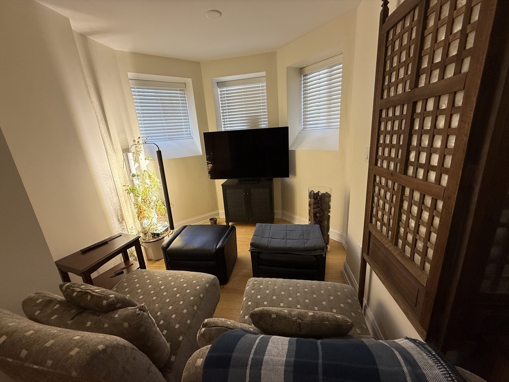 20 Chapel Street, Unit C308 Brookline, MA 02446 - Photo 4 of 15 a living room with furniture and a flat screen tv