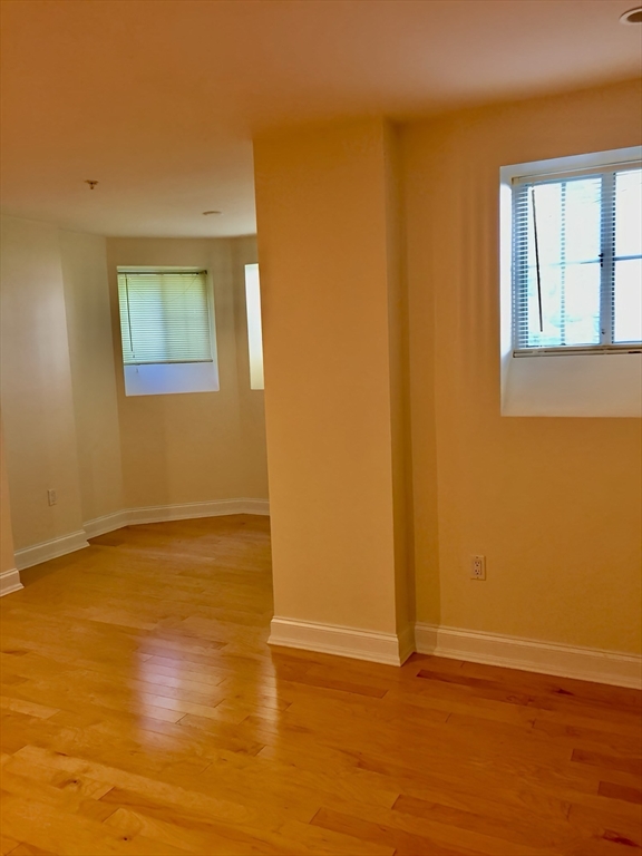 20 Chapel Street, Unit C308 Brookline, MA 02446 - Photo 5 of 15 a view of an empty room with wooden floor and a window