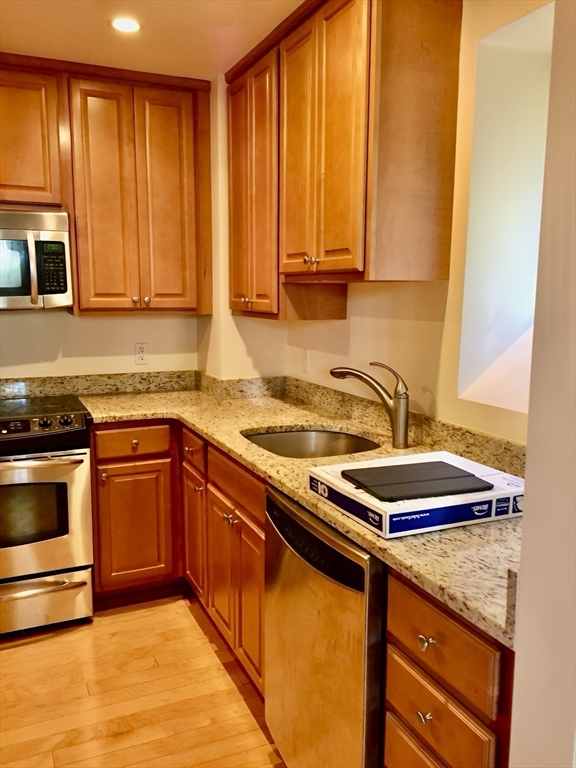20 Chapel Street, Unit C308 Brookline, MA 02446 - Photo 6 of 15 a kitchen with stainless steel appliances granite countertop a sink stove and cabinets