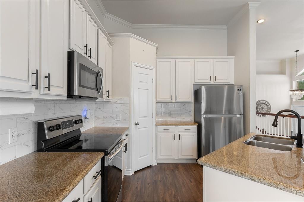 18240 Midway Road, Unit 1301 Dallas, TX 75287 - Photo 4 of 25 Modern kitchen featuring white cabinetry with matte black hardware, stainless steel appliances, and a double basin sink