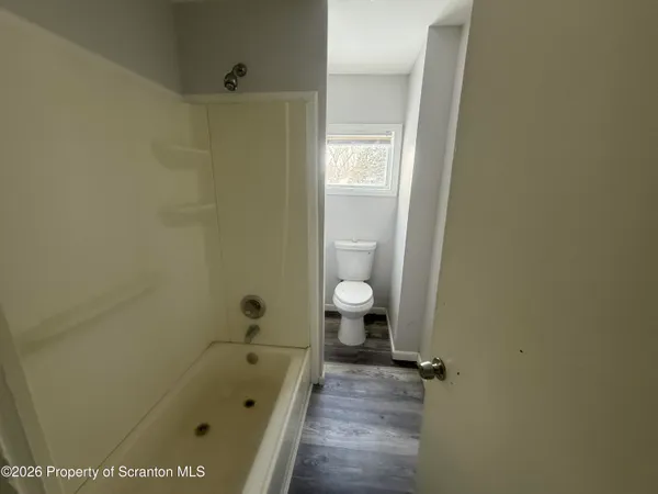 a bathroom with a granite countertop sink a toilet and shower