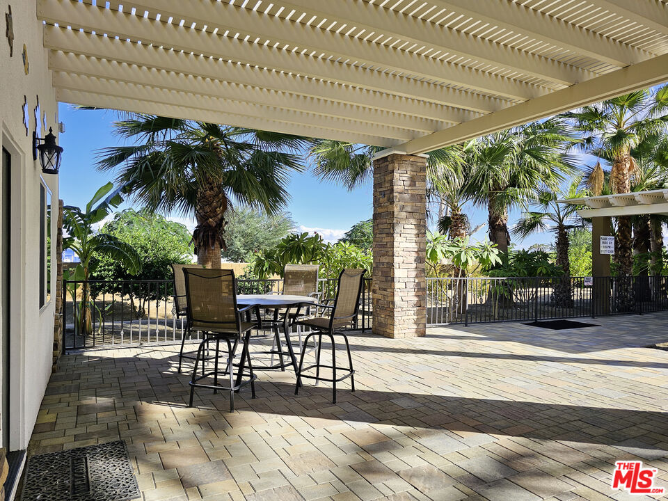 38580 Rancho Los Cerritos Drive, Unit S1 Indio, CA 92203 - Photo 16 of 39 a patio with glass top table and chairs