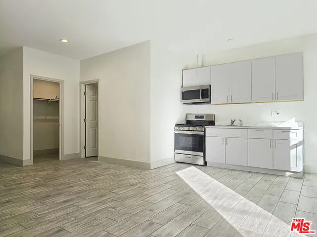 a kitchen with granite countertop a stove a sink and a refrigerator