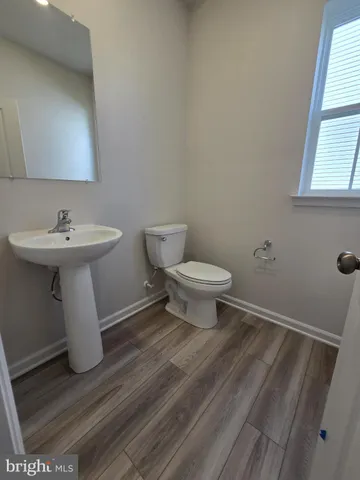 a bathroom with a sink toilet and window