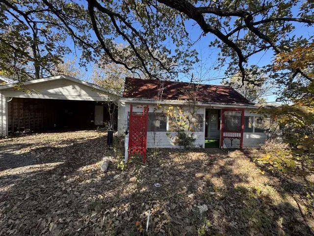 a view of a house with a tree and wooden fence