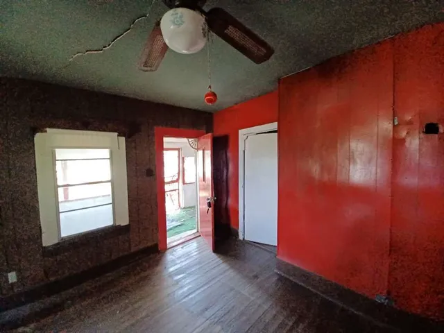 a view of an empty room with a fireplace and a window