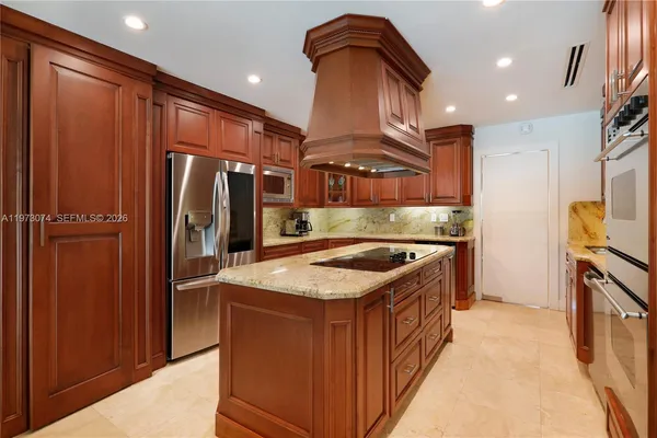 a kitchen with stainless steel appliances granite countertop a refrigerator a stove and a wooden floors