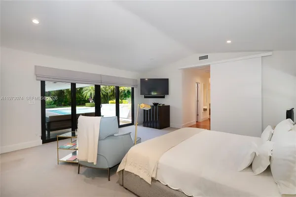 a bedroom with a bed and large windows