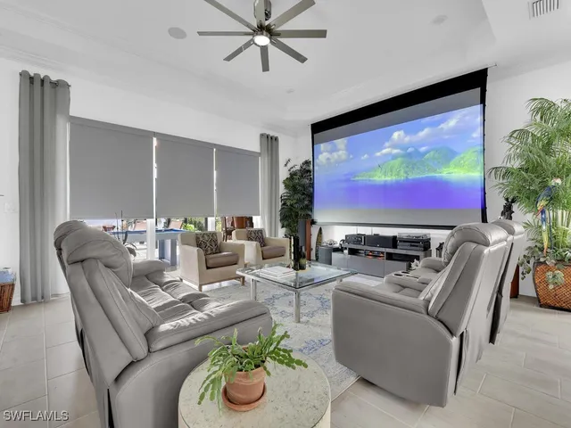a living room with furniture a flat screen tv and a floor to ceiling window