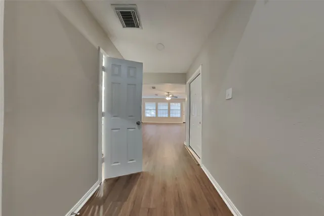 a view of a hallway with wooden floor