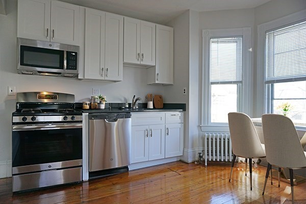 141 Brown Street, Unit 2F Waltham, MA 02453 - Photo 2 of 8 a kitchen with stainless steel appliances granite countertop a stove a sink and a microwave