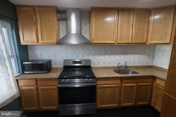 a kitchen with stainless steel appliances granite countertop a sink stove and cabinets