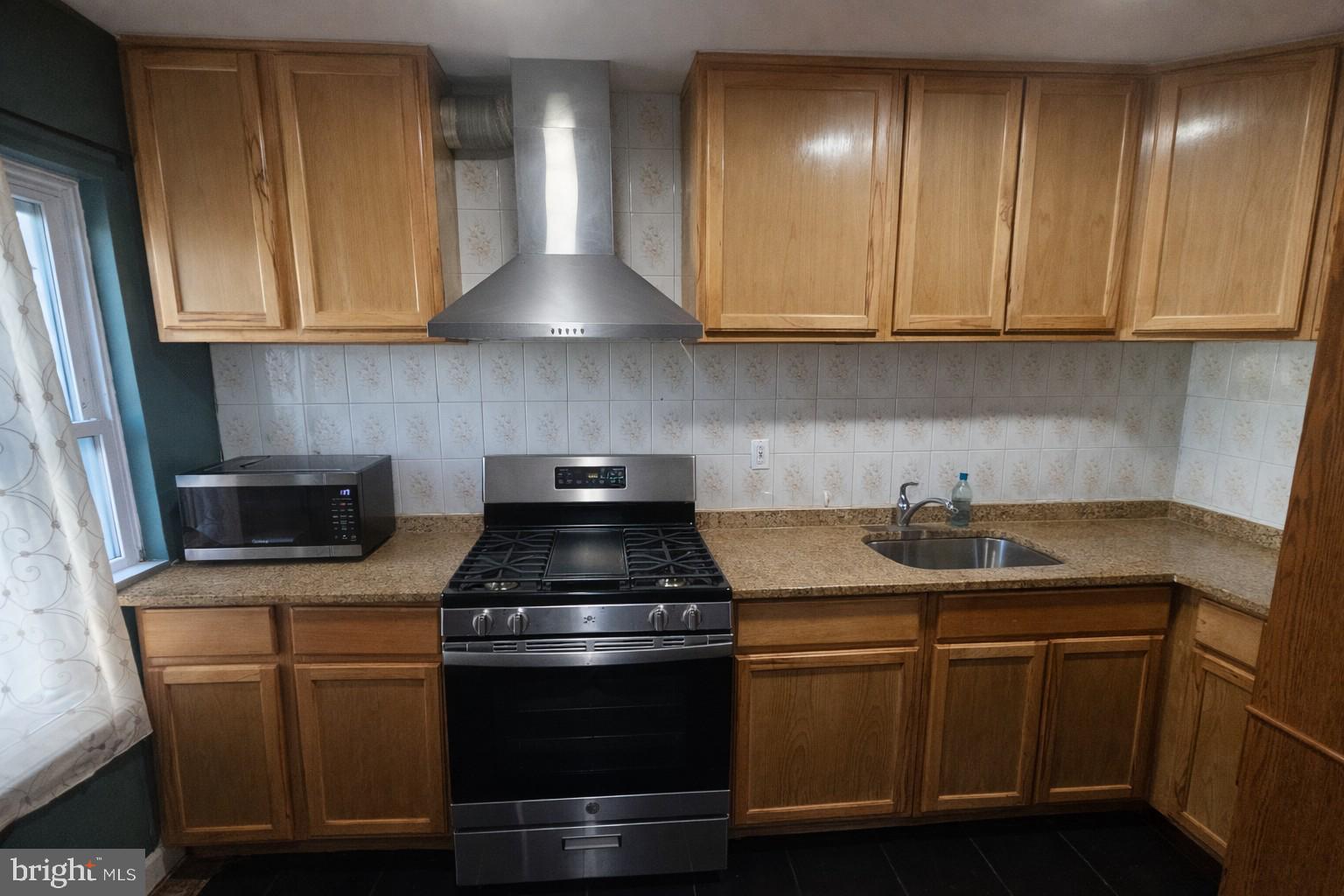 1315 Honan Street Chester, PA 19013 - Photo 4 of 15 a kitchen with stainless steel appliances granite countertop a sink stove and cabinets