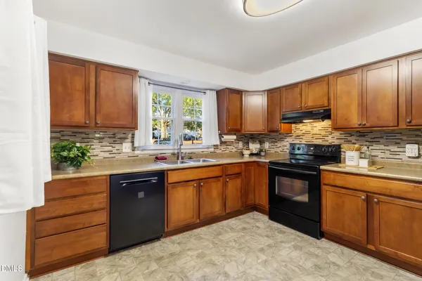 a kitchen with stainless steel appliances granite countertop a stove sink and cabinets