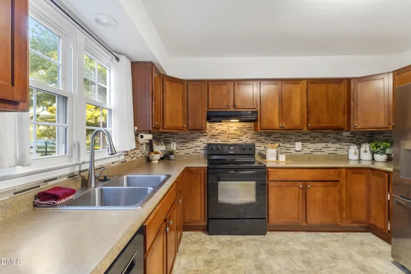 a kitchen with stainless steel appliances granite countertop a sink stove and cabinets
