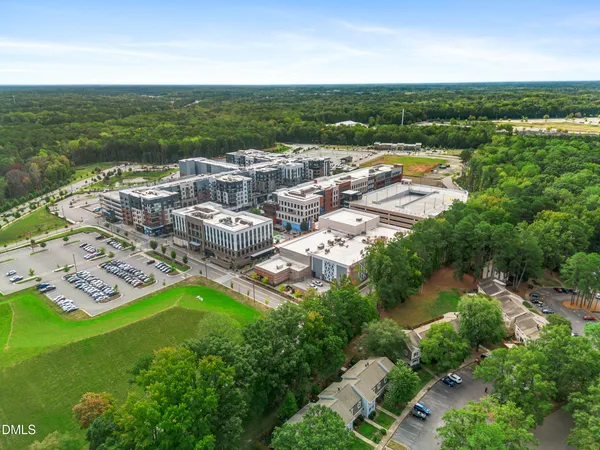 an aerial view of residential houses with outdoor space and trees