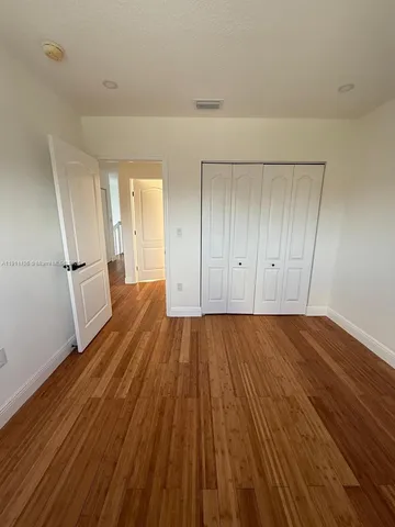 a view of a room with wooden floor and electronic appliances