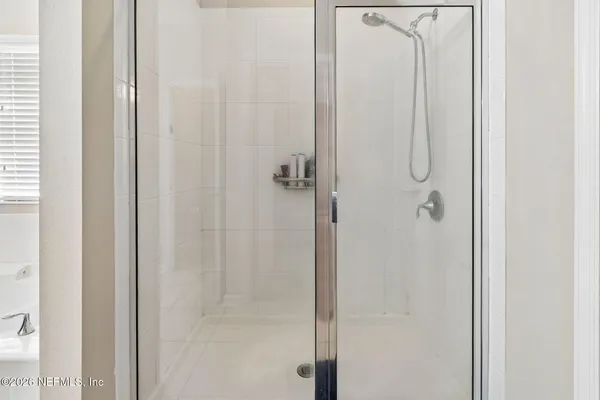 a large bed sitting in a bedroom next to a window and a lamp