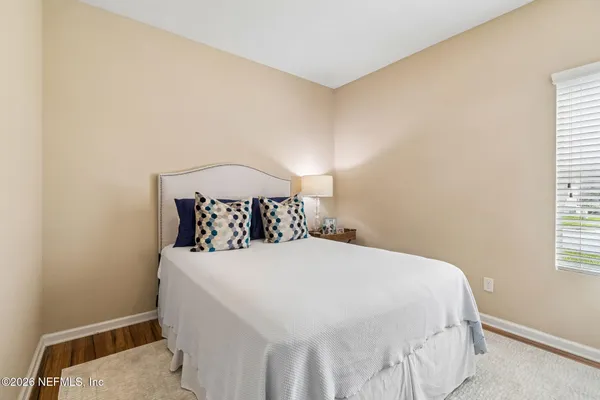 a bedroom with a bed and a window with chair