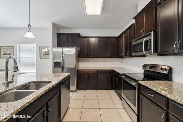 a kitchen with granite countertop a sink stainless steel appliances and cabinets