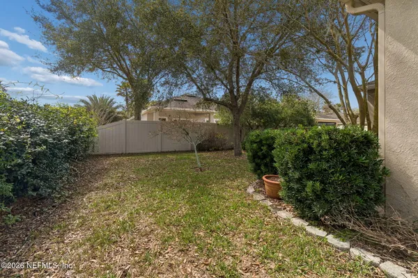 a view of a house with brick walls and a yard with plants