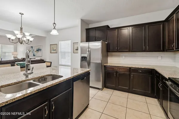 a kitchen with stainless steel appliances granite countertop a stove microwave and sink
