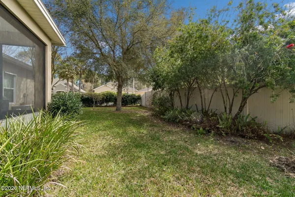 an aerial view of residential houses with outdoor space and trees