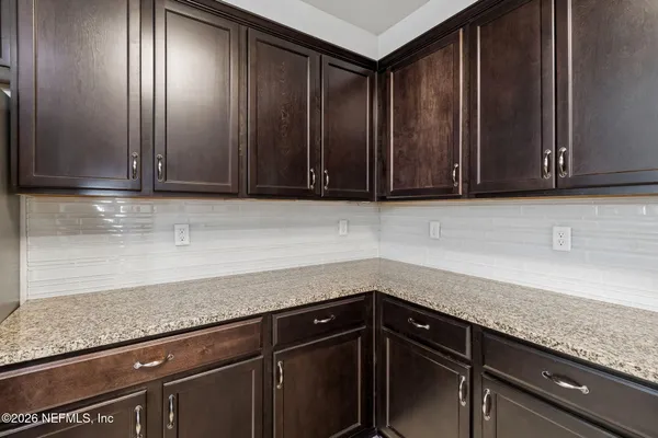 a kitchen with granite countertop a sink a counter top space appliances and cabinets