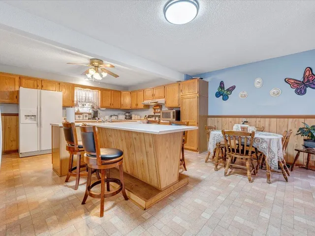 a room with stainless steel appliances kitchen island granite countertop furniture and a large window
