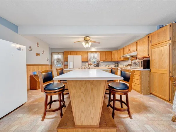 a kitchen with stainless steel appliances a dining table chairs and a refrigerator