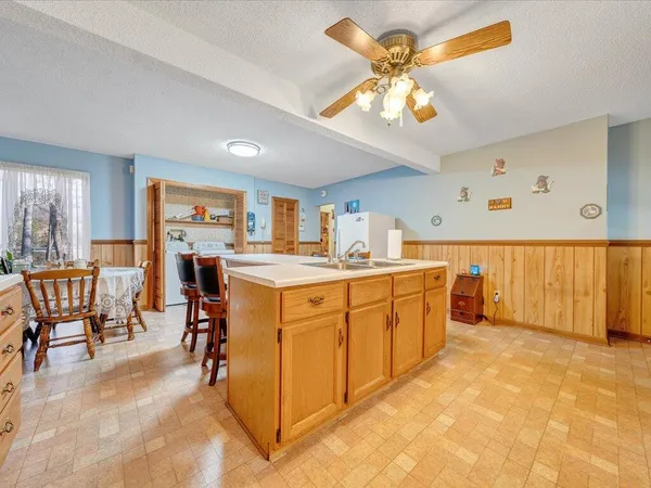 a kitchen that has cabinets a sink and appliances