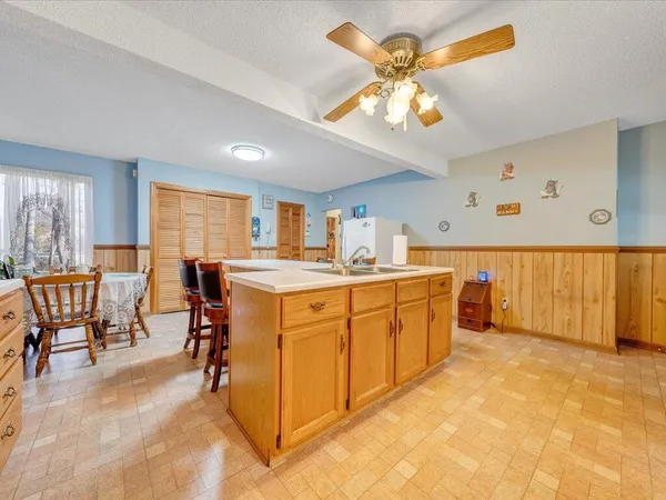 a kitchen with stainless steel appliances granite countertop a sink cabinets and wooden floor