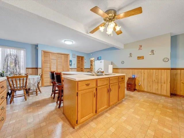 a kitchen with stainless steel appliances granite countertop a sink cabinets and wooden floor