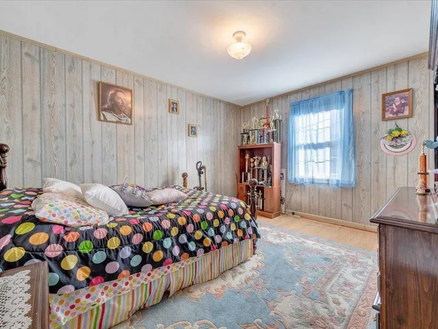 a bedroom with a bed and a painting on the wall