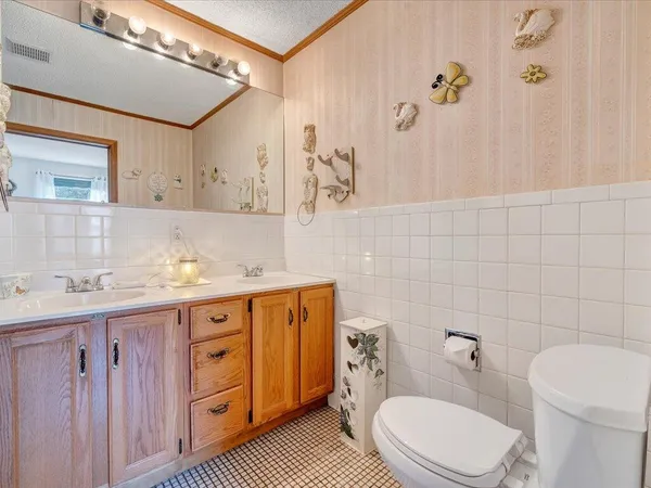 a bathroom with a granite countertop sink mirror vanity and toilet