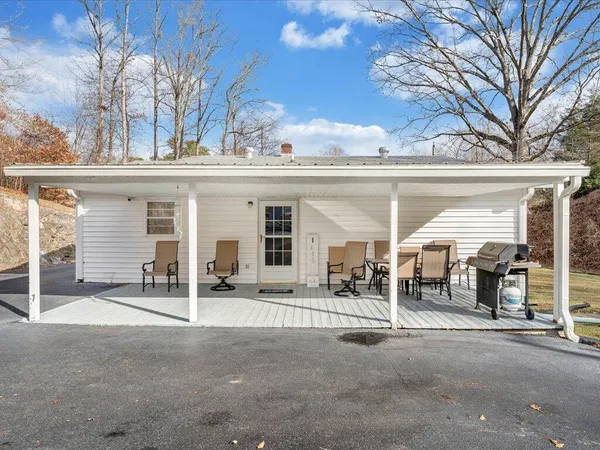 a view of a house with backyard and trees
