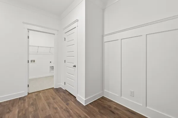 a kitchen with stainless steel appliances granite countertop a sink a stove a refrigerator and white cabinets with wooden floor