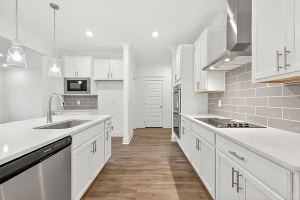 a view of kitchen with stainless steel appliances granite countertop a white stove top oven and white cabinets